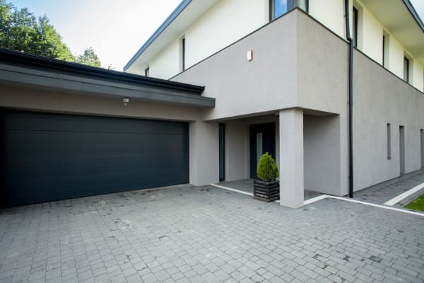 Modernes Einfamilienhaus mit gepflasterter Einfahrt.