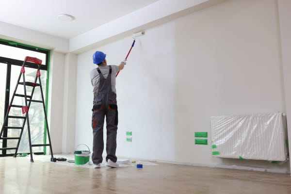 Malermeister streicht eine Wand weiß