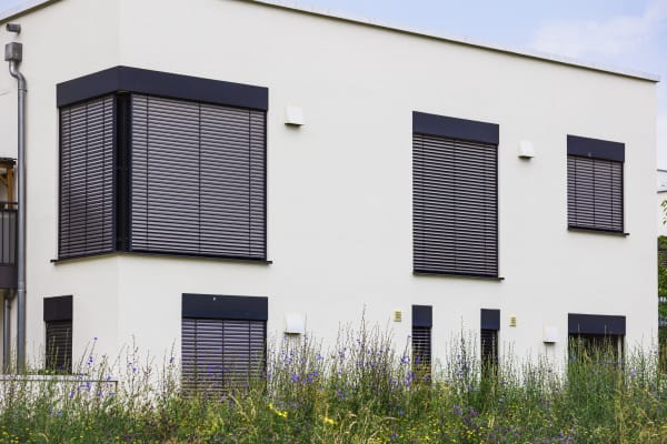 Das Bild zeigt moderne Rollladen an einem weißen Gebäude.
