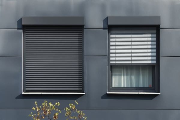 Das Bild zeigt eine Hausfassade mit Rollladen und Jalousie
