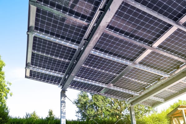 Glas-Glas-Solarmodule bilden die Überdachung einer Terrasse im Garten.