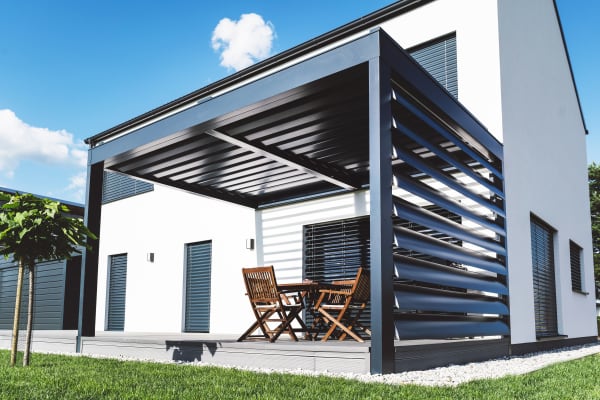 Verstellbarer Lamellen-Sichtschutz an einer modernen Terrassenüberdachung aus Alu