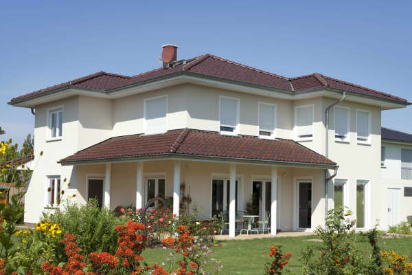 zweistöckiges Haus mit einer Terrasse mit Ziegeldach