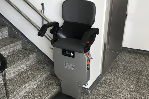 Treppenlift zum Stehen in einem Mehrfamilienhaus.