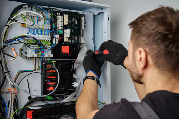 Monteur arbeitet an der Elektronik einer Wärmepumpe