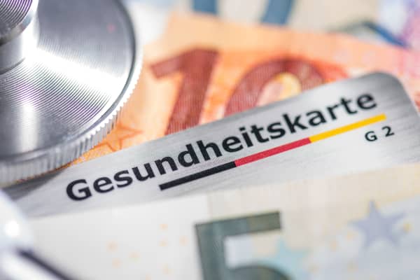 Nahaufnahme von Gesundheitskarte, Euroscheinen und Stethoskop