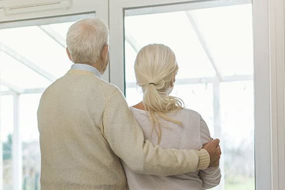 Älteres Ehepaar schaut aus dem Fenster