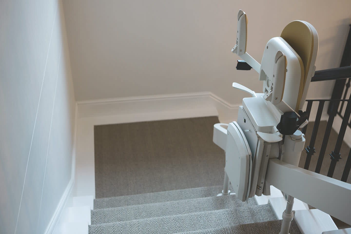 Eingeklappter Treppenlift mittig auf einer Treppe im Wohnhaus