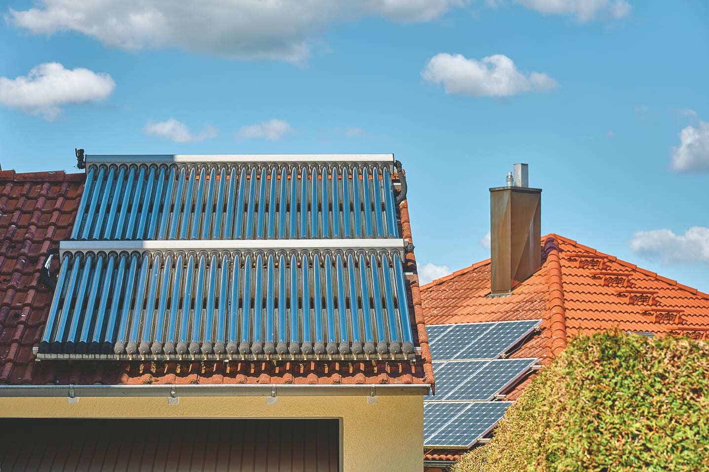 Solarthermie auf einem roten Ziegeldach eines Einfamilienhauses.