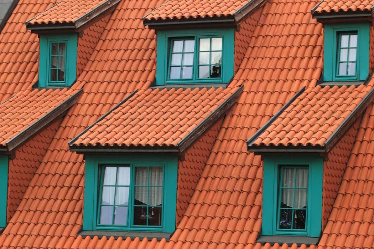 Haus mit roten Dachziegeln und grünen Sprossenfenstern