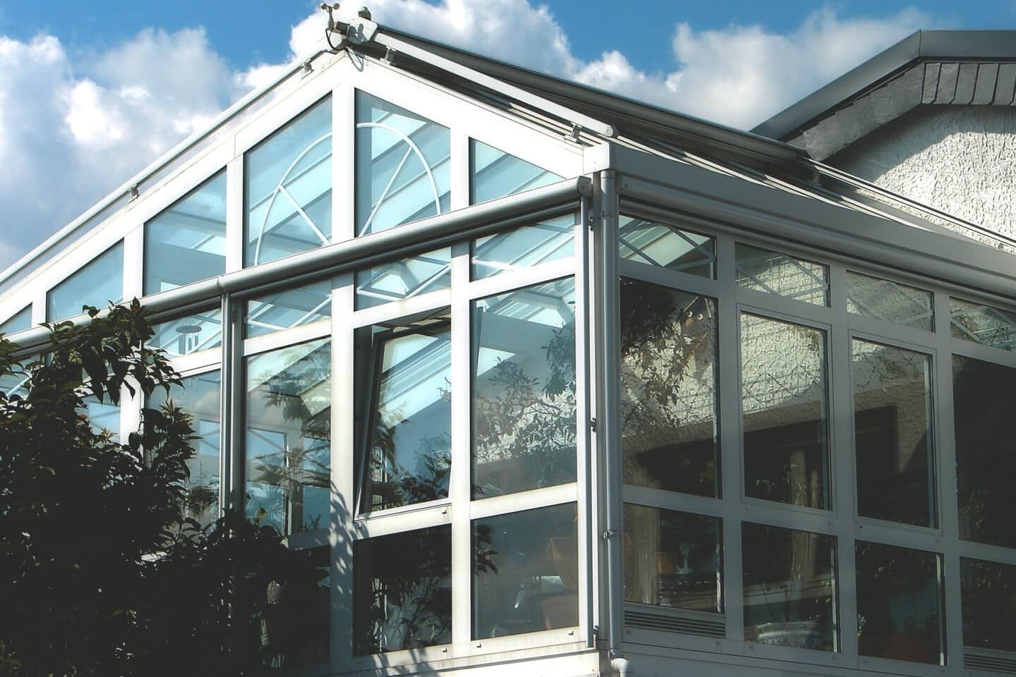Wintergarten mit weißen Rahmen und großen Fensterfronten