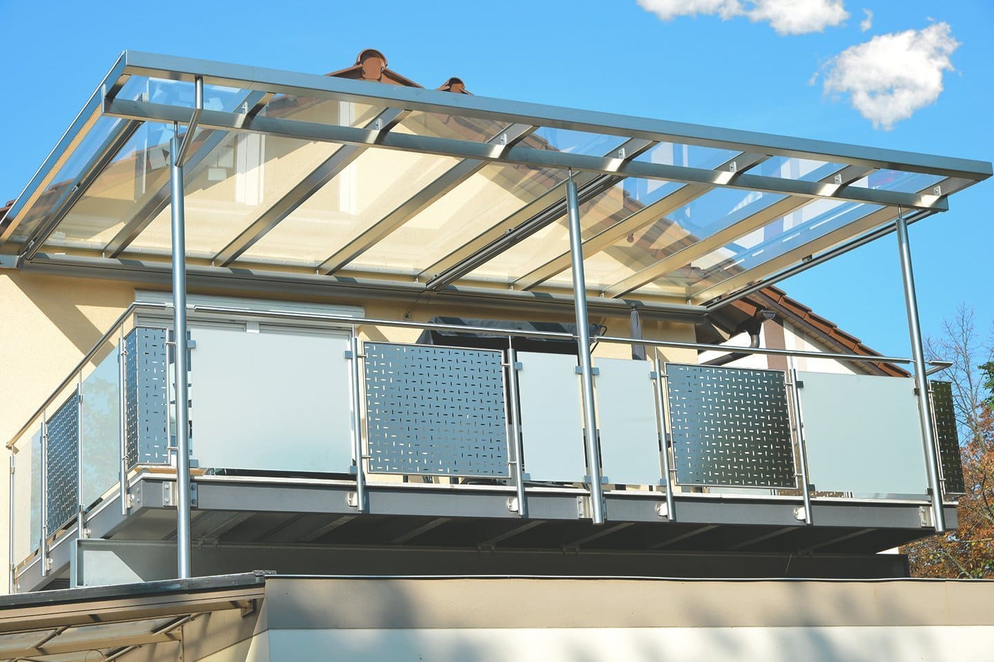 Terrassenüberdachung mit Glasdach an einem Balkon mit Brüstung