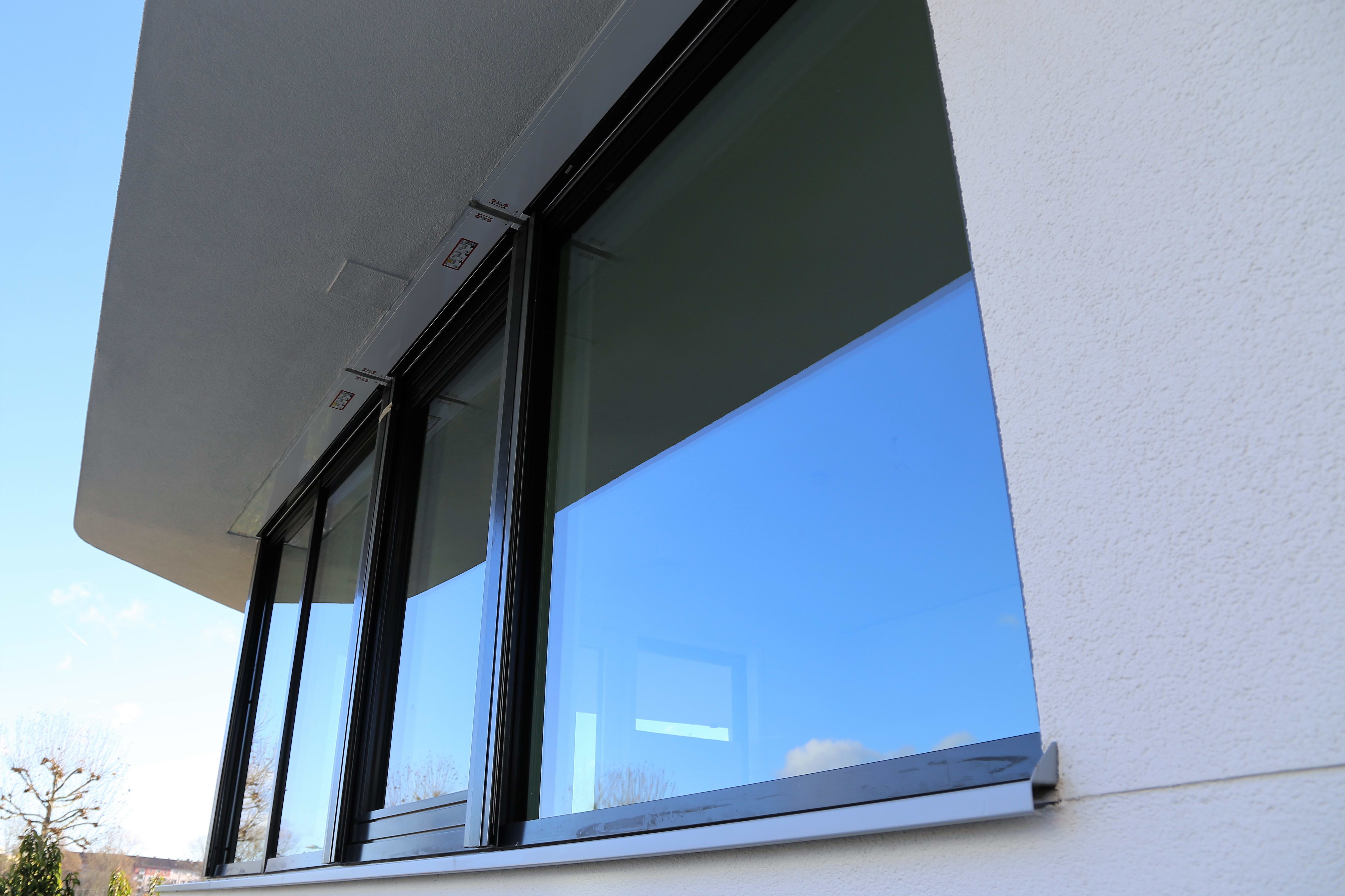 Große moderne Fensterfront mit schwarzem Rahmen an weißer Fassade