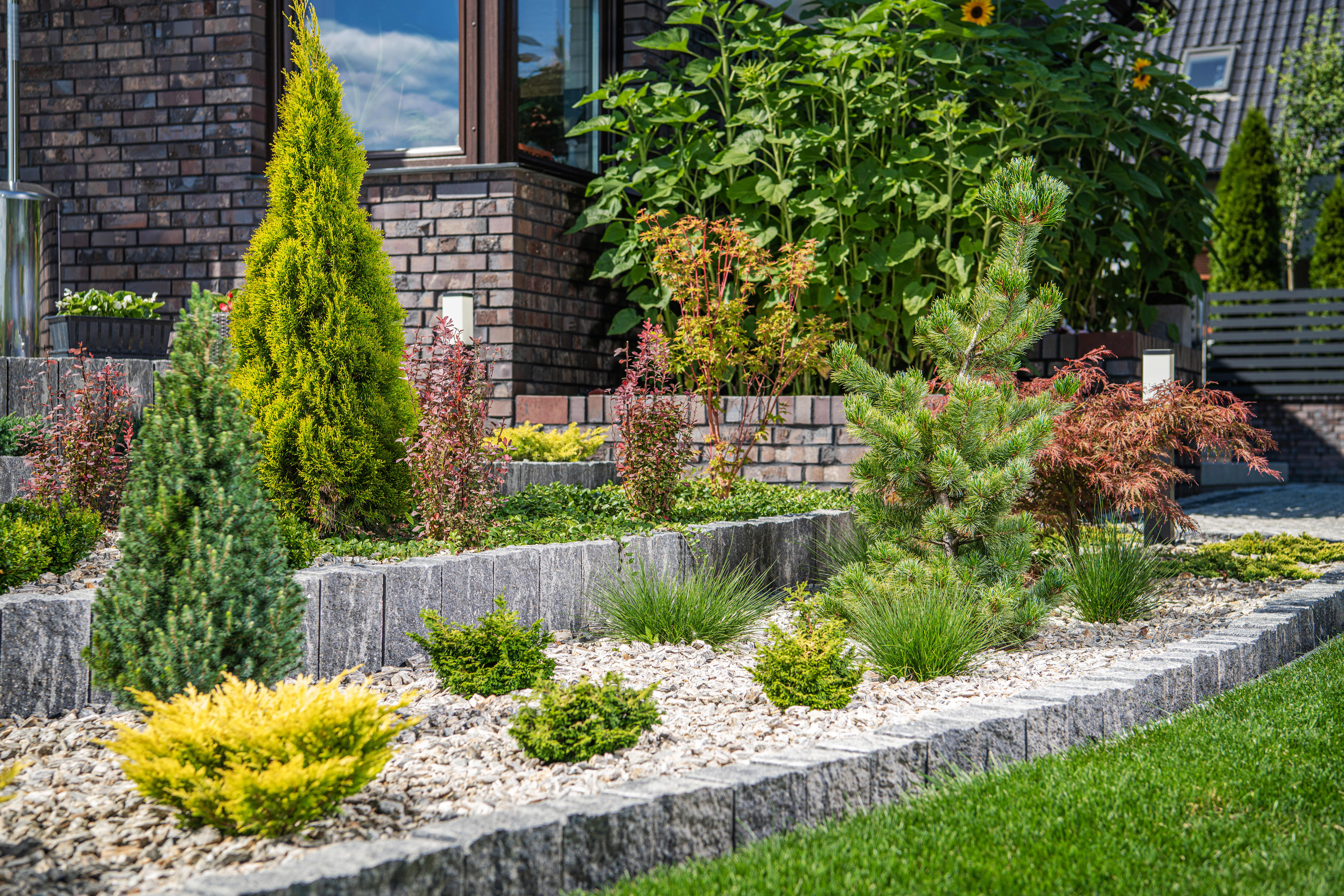 Garten mit Steinbeete und Pflanzen.