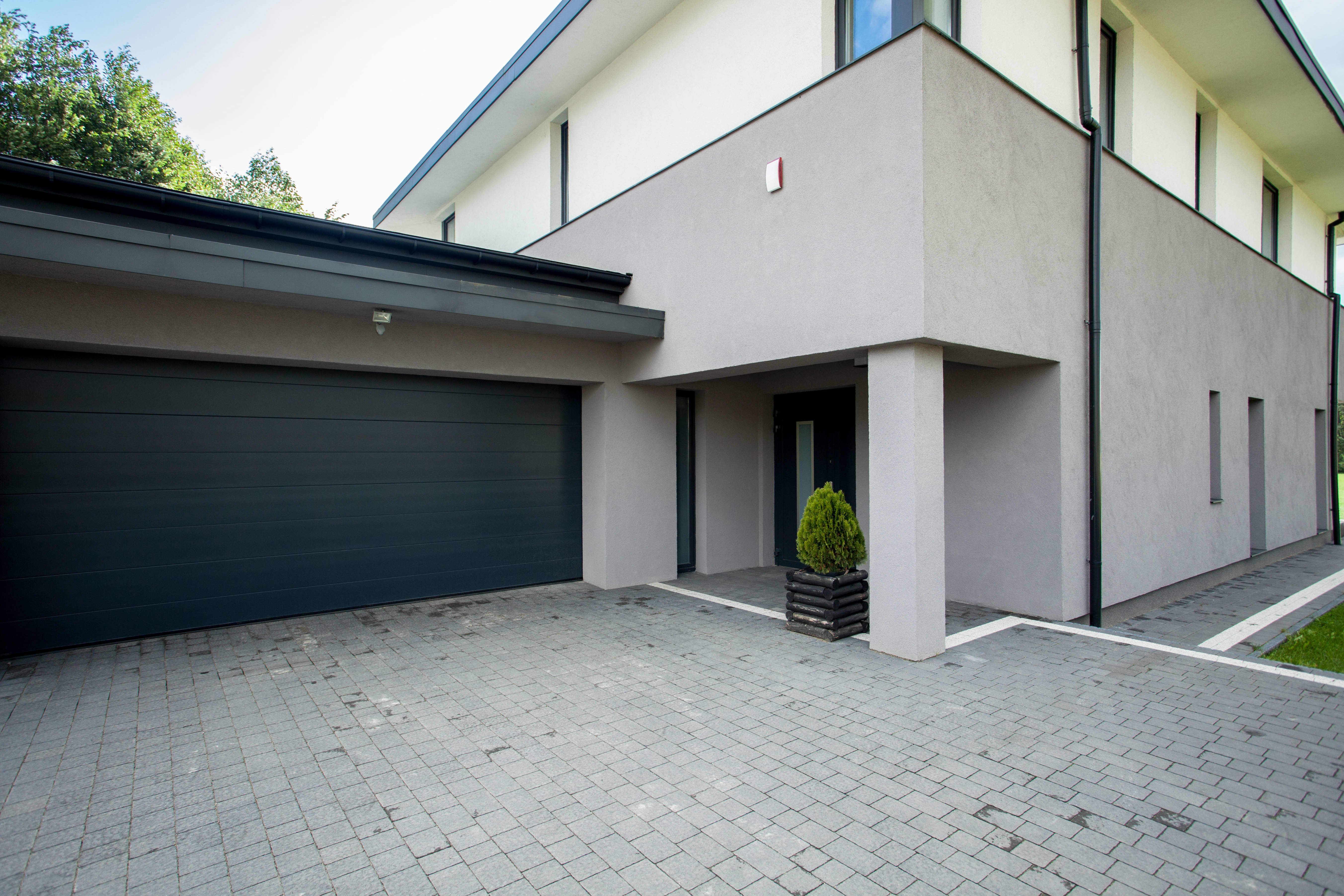 Modernes Einfamilienhaus mit gepflasterter Einfahrt.