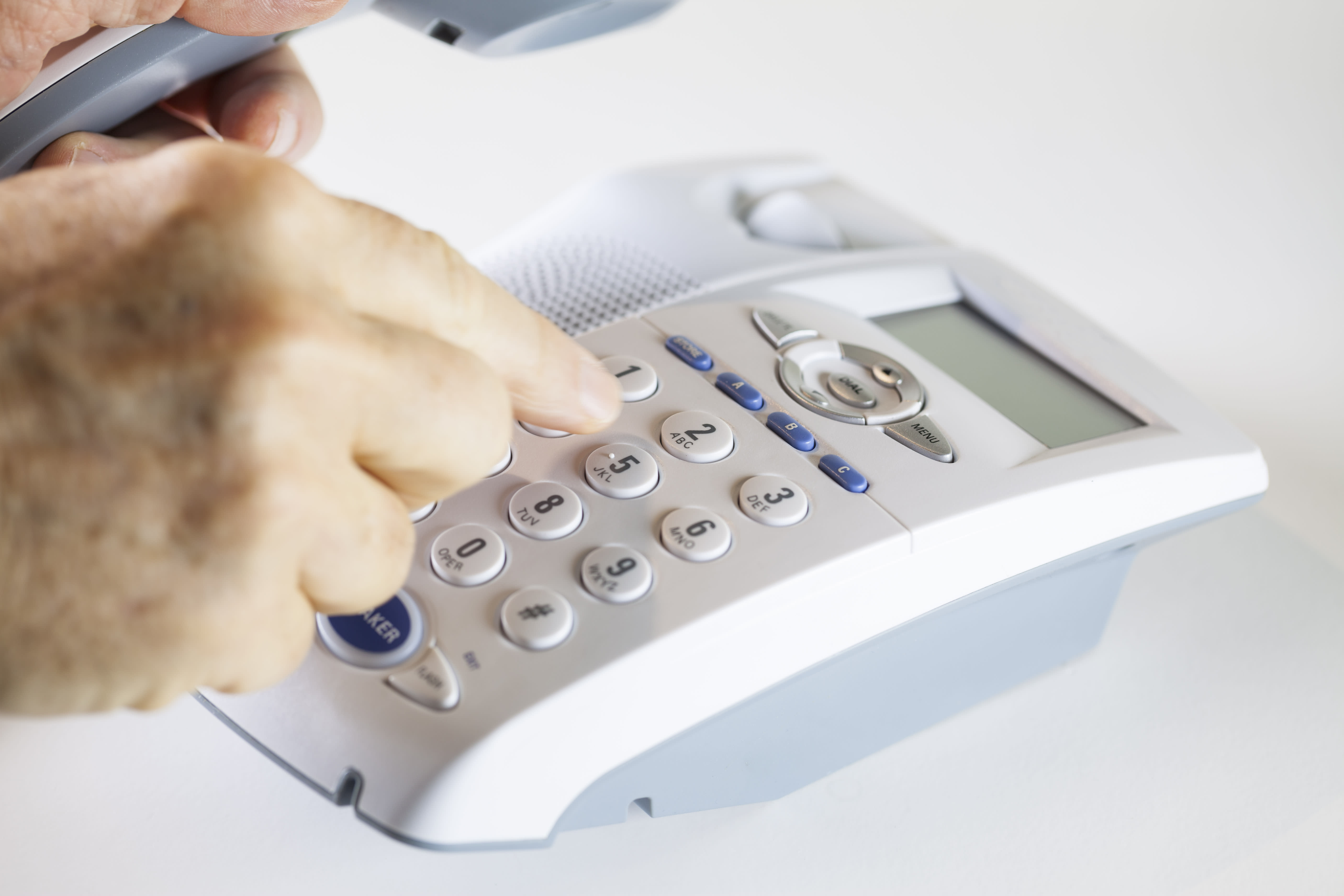 Rentner wählt auf einem Notruftelefon