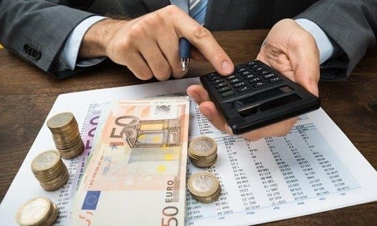 Ein Mann im Anzug berechnet die Beträge und zählt das Geld.