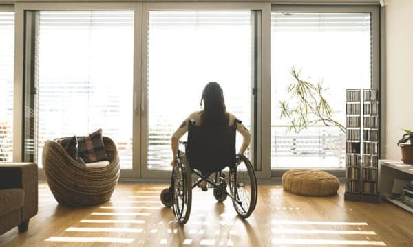 Frau in Rollstuhl im Wohnzimmer