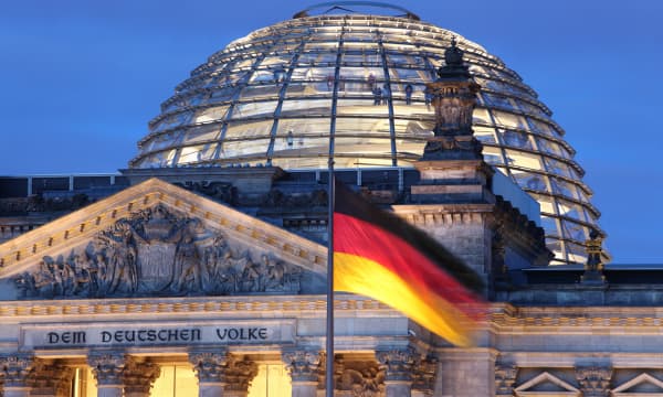 Reichstag in Berlin in der Dämmerung mit deutscher Flagge