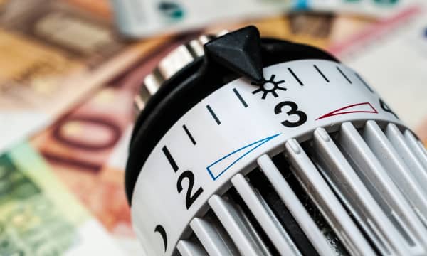 Nahaufnahme eines Heizthermostats mit Euroscheinen im Hintergrund