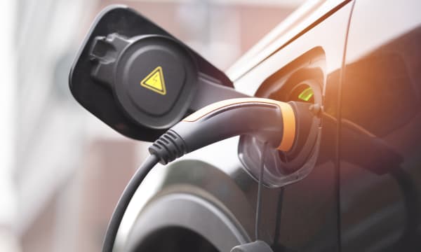 Nahaufnahme des Ladesteckers in einem dunklen E-Auto