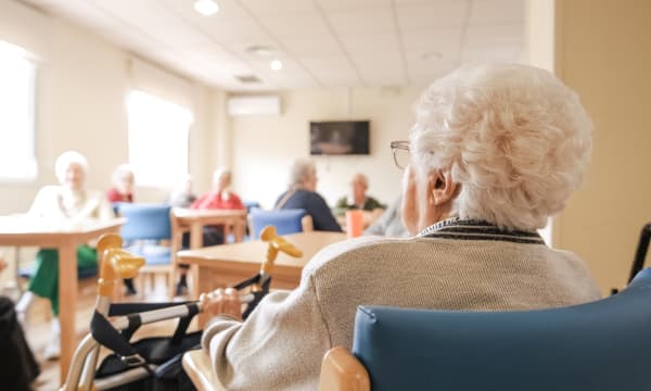 Senioren und Seniorinnen im Aufenthaltsraum eines Pflegeheims