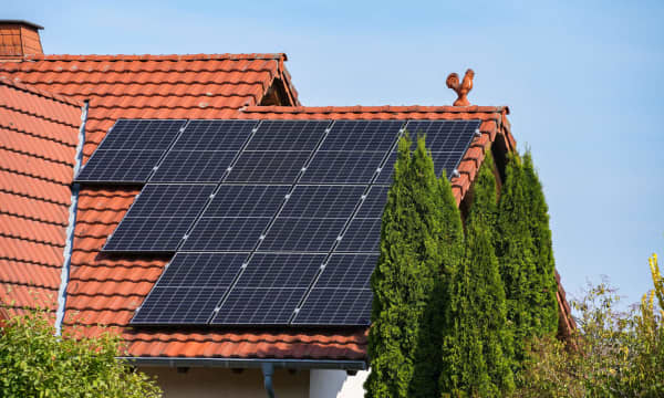 Solarmodule auf rotem Ziegeldach eines Wohnhauses