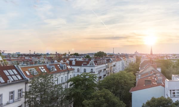 Blick über die Dächer von Mehrfamilienhäusern in einer Stadt bei Sonnenuntergang