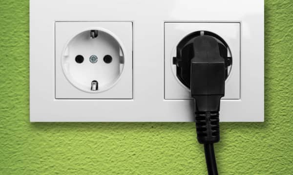 Doppelsteckdose mit schwarzem Stecker in der Wand