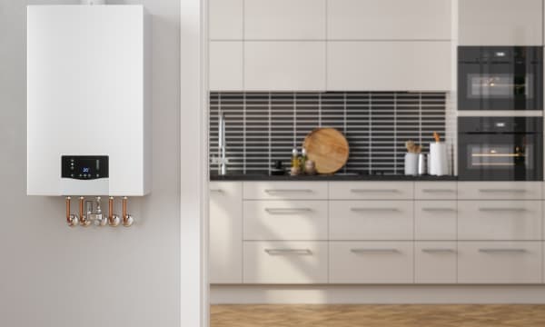 Moderne Gastherme mit weißer Küchenzeile im Hintergrund