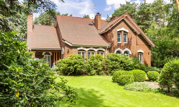 Großes freistehendes Einfamilienhaus mit Ziegelfassade in grünem Garten