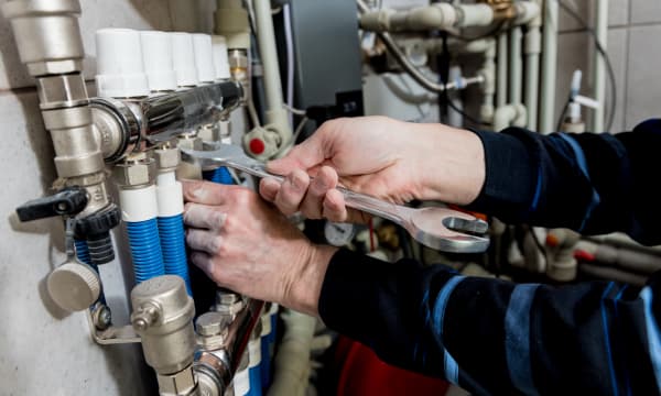 Ansicht der Hände eines Handwerkers, der an einer Heizung arbeitet