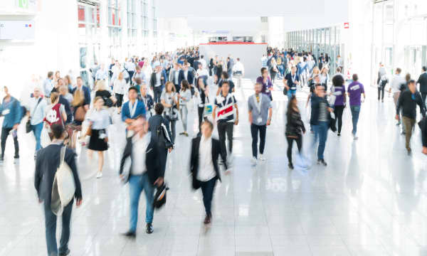 Verschwommene Menschen in einer Veranstaltungshalle auf einer Messe