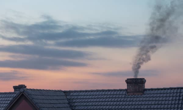 Schornstein mit Rauch und Sonnenuntergang