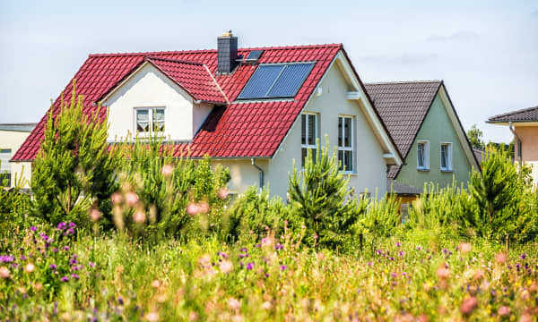 Moderne sanierte Einfamilienhäuser mit grüner Wiese im Vordergrund