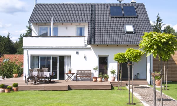 Weißes freistehendes Einfamilienhaus mit Terrasse im Grünen