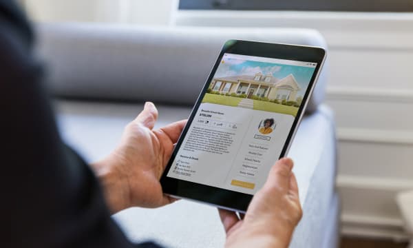 Person sieht sich das Inserat einer Immobilie auf einem Tablet an