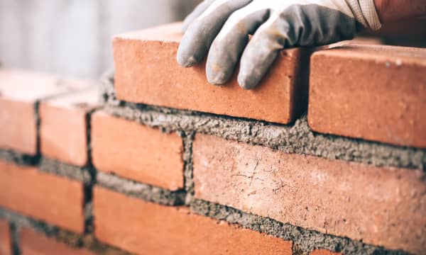 Nahaufnahme der Hand eines Maurers bei der Arbeit