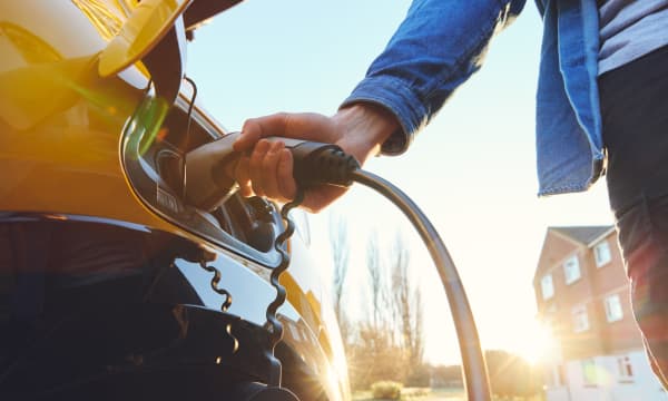 Elektroauto wird auf der Straße vor einem Haus geladen