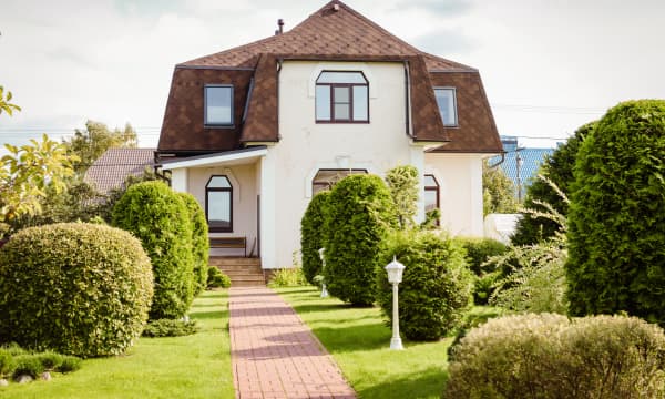Freistehendes, älteres Einfamilienhaus mit brauner Dacheindeckung in gepflegtem Garten