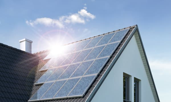 Sonne spiegelt sich in Solarmodulen auf dem Dach eines Wohnhauses
