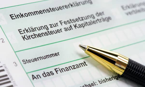 Nahaufnahme einer deutschen Einkommensteuererklärung, auf dem Formular liegt ein Kugelschreiber