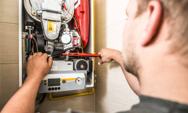 Monteur arbeitet an einer Gastherme