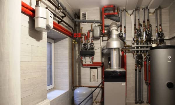 Heizsystem im Heizraum mit Kessel, Wassererhitzer, Ausdehnungsgefäß und Heizungsrohren