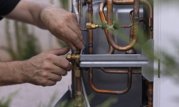 Installateur arbeitet an einer Wärmepumpe