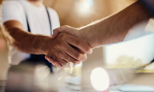 Nahaufnahme zweier Männer, die sich die Hand geben