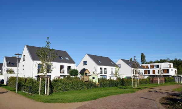 Mehrere moderne, weiße Einfamilienhäuser in ruhiger Wohngegend