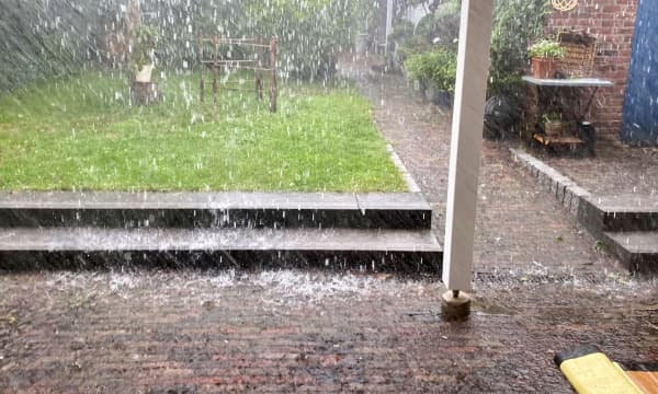 Starker Regen mit viel Wasser auf einer Terrasse