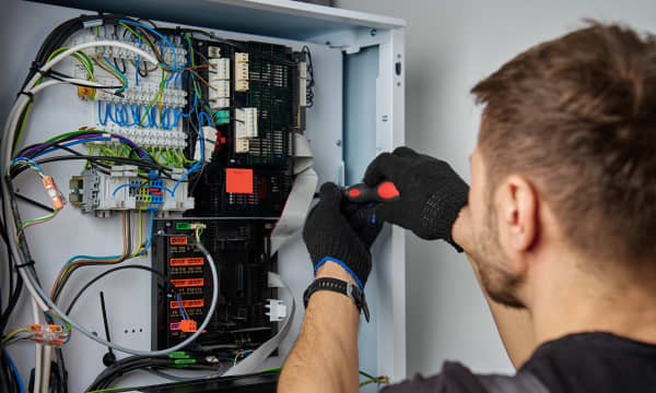 Monteur arbeitet an der Elektronik einer Wärmepumpe