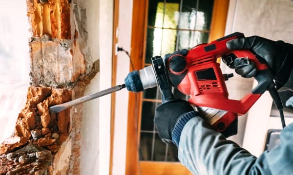 Arbeiter führt einen Wanddurchbruch durch